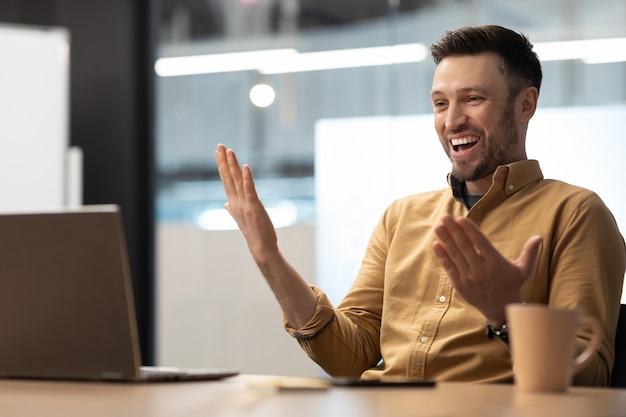 Unternehmer, der einen Videoanruf hat und mit einem Laptop im Büro spricht