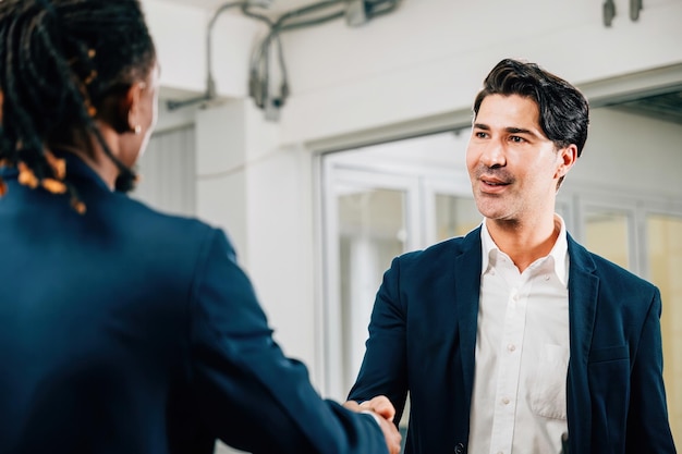 Unternehmer und Unternehmerinnen schütteln sich in einem Büro die Hand, um ihre erfolgreiche Partnerschaft zu feiern Kollegen aus verschiedenen Berufen schließen ein produktives Treffen Teamarbeit