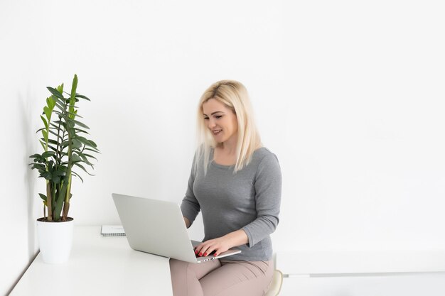 Unternehmerfrau, die mit einem zu Hause sitzenden Laptop arbeitet.