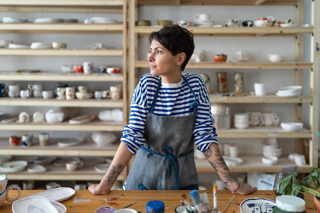 Unternehmerin bastelt Frau im Töpferatelier und bereitet sich auf Meisterkurs oder Arbeitsprozess vor