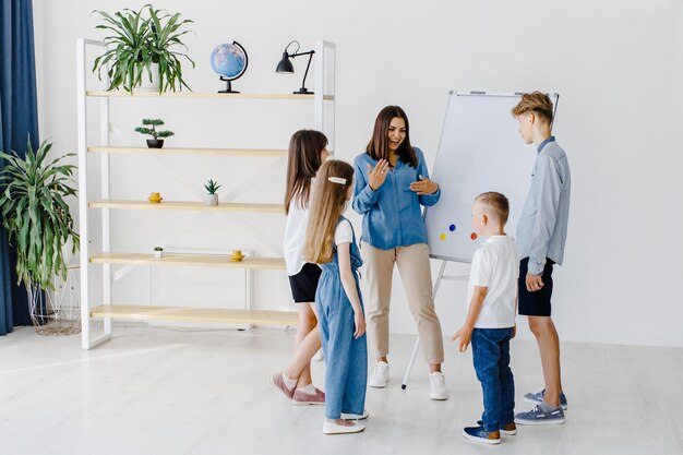 Unterricht erklären und Board verwenden Gruppe von Kindern Schülern unterschiedlichen Alters im Unterricht in der Schule mit Lehrer Lernkonzept