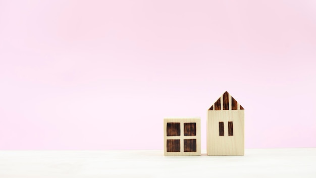 Unterschied drei Hausmodelle auf pastellrosa Hintergrund
