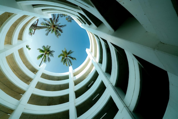 Untersicht Parkhaus mit Kokospalme über dem Gebäude im Sommer Multilevel