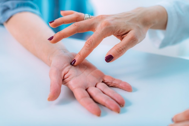 Untersuchung der Hand eines älteren Patienten mit Karpaltunnelsyndrom Nahaufnahme des Handgelenks einer älteren Frau