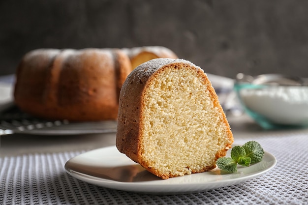 Untertasse mit köstlichem Joghurtkuchen auf Tischdecke