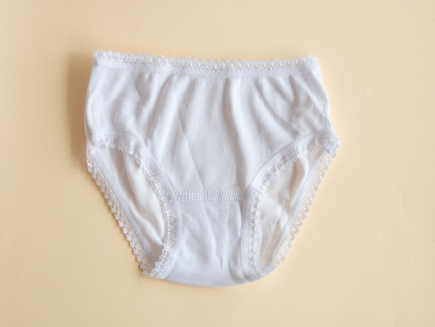 Unterwäsche für Kinder Weißes Höschen für Mädchen auf beige gestrickter Baumwollunterwäsche Unterwäsche für Kinder