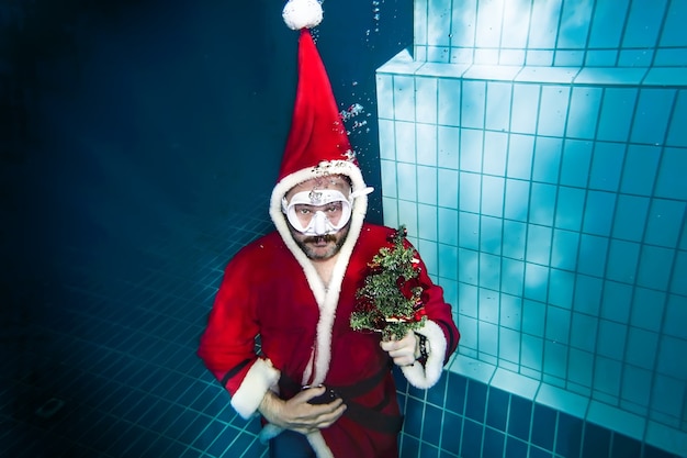 Unterwasser-Weihnachtsmann mit wunderschönem Weihnachtsbaum taucht aus der Tiefe auf