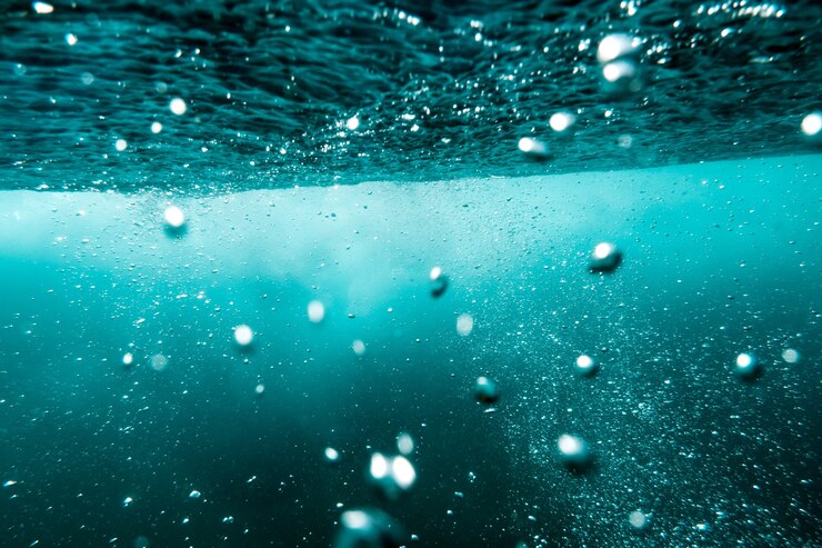 Unterwasseransicht von Blasen im tiefblauen Meer. Schließen Sie herauf Wasser.