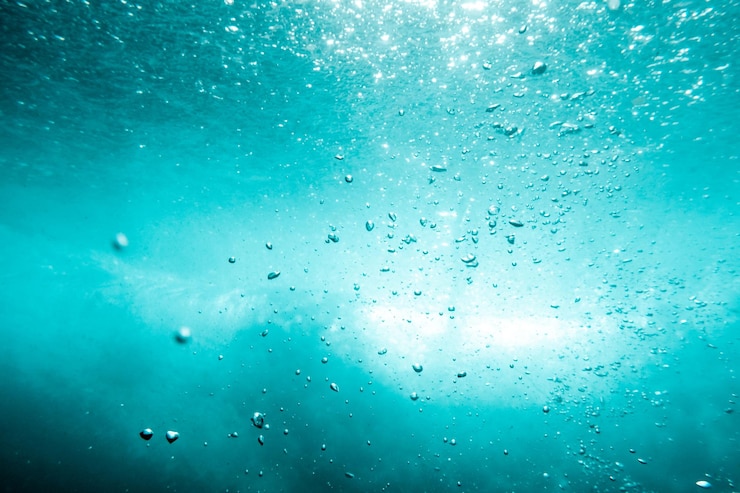 Unterwasseransicht von Blasen im tiefblauen Ozean Nahaufnahme Wasser Hintergrund