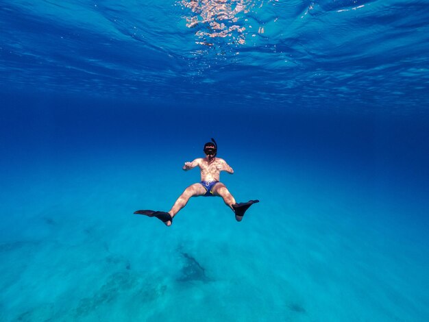 Unterwasserfoto des freien Tauchens des Mannes im klaren Meer