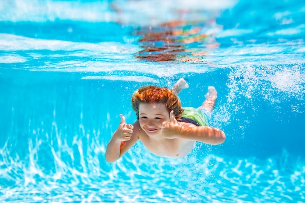 Unterwasserkind schwimmt im Pool Gesundes Kind schwimmt und hat Spaß unter Wasser