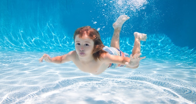 Unterwasserkinder schwimmen unter Wasser im Schwimmbad