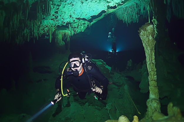 Unterwasserwelt Höhle von Yucatan Cenote, dunkle Landschaft der unterirdischen Stalaktiten, Taucher