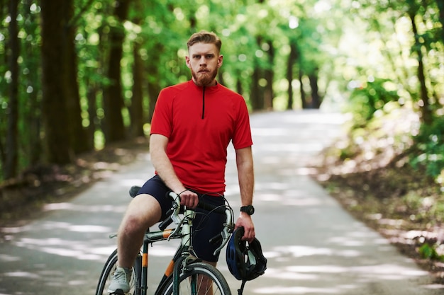 Unterwegs. Radfahrer auf einem Fahrrad ist im Wald an sonnigem Tag