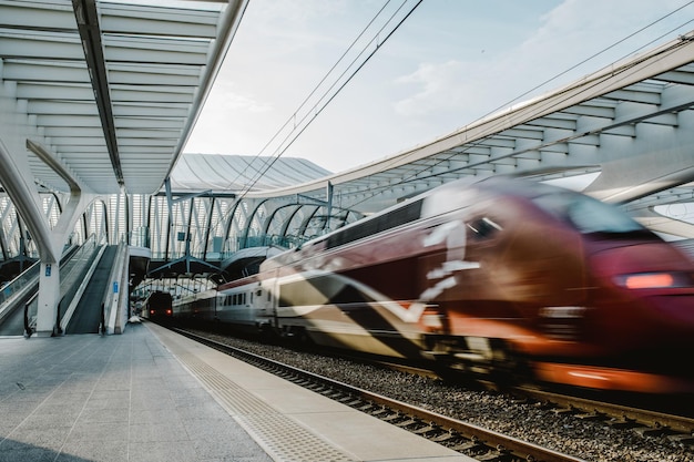 Unübersichtliche Bewegung des Zuges auf dem Bahnhofsplattform gegen den Himmel