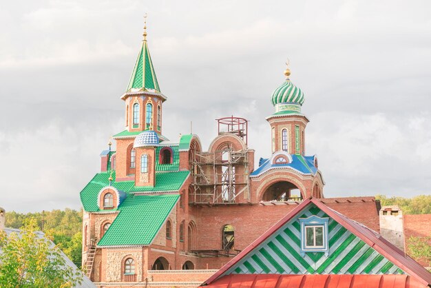 Unvollendete Moschee aus roten Backsteinen mit grüner Kuppel und goldenem Turm