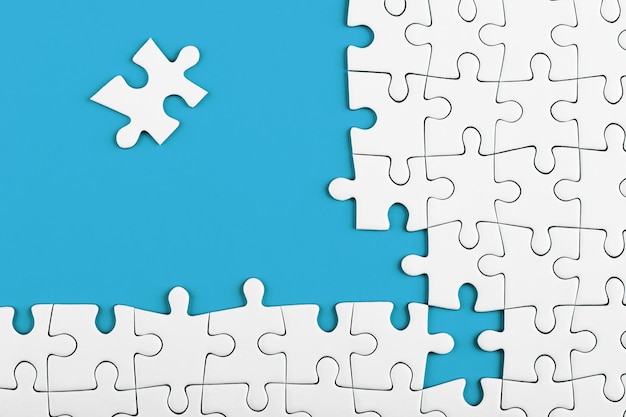 Unvollendete weiße Puzzleteile auf blauem Hintergrund Geschäftskonzept