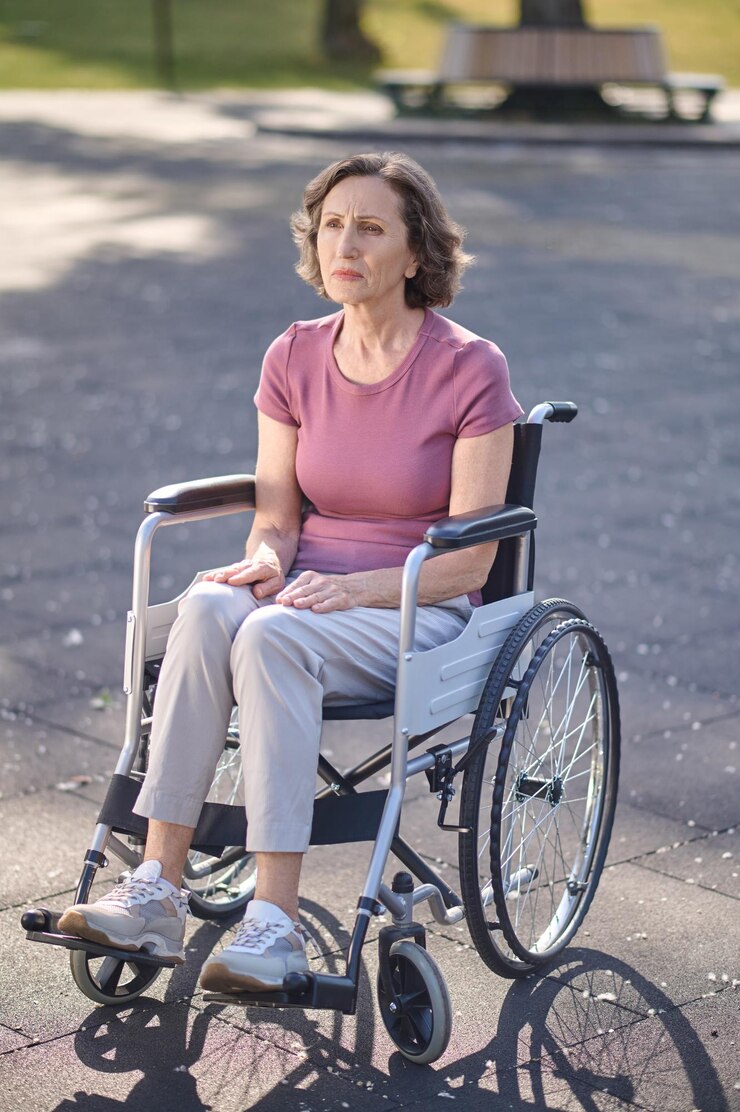 Foto unzufrieden. behinderte frau mittleren alters, die mit einem unglücklichen blick in einem rollstuhl sitzt