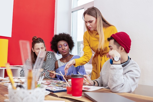 Unzufrieden mit dem Verhalten. Der blonde junge Lehrer fühlt sich mit dem Verhalten der Schüler unzufrieden