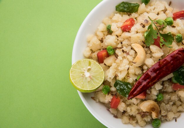 Upma o Uppittu es un plato de desayuno popular en el sur de la India y Maharashtra. Sémola o Rava o harina de arroz grueso son los ingredientes principales. Servido en un bol sobre fondo de madera o colores