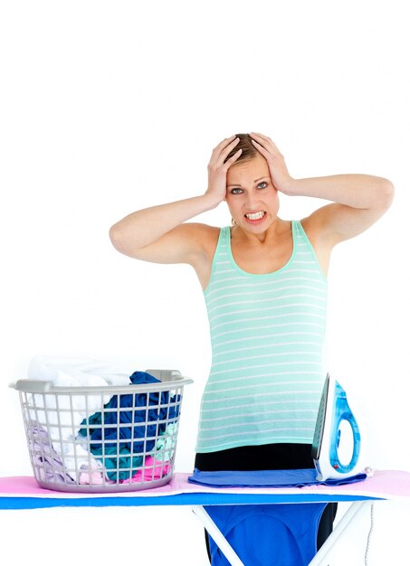 Upset woman ironing