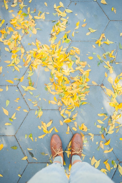 Urban Woman Vintage Schuhe mit gelbem Herbstlaub auf Beton