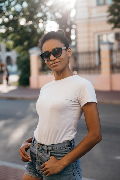 Urbana afro americana mulher andando na praça da cidade rua por do sol