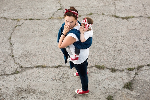 Urbaner familienlook von mutter und baby im tragetuch