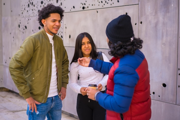 Urbaner Stil, drei schwarze Latino-Freunde, die Spaß auf der Straße haben und miteinander reden.