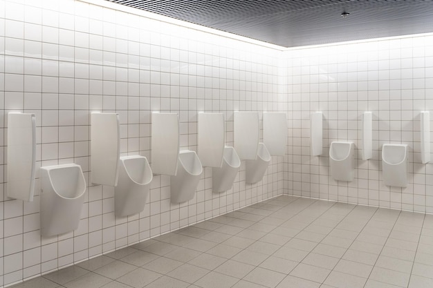 Foto urinale der weißen männer an der fliesenwand. leere öffentliche toiletten, saubere toilettenkonzepte