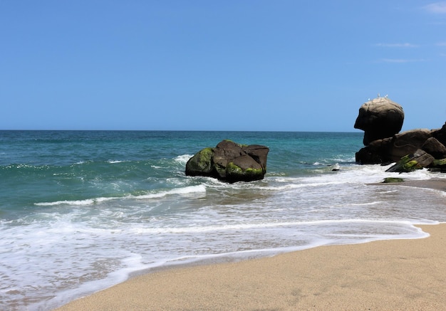 Urlaub am Meer Wellen Steine und Spritzer glitzern in der Sonne Strandurlaub