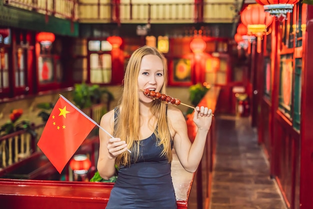 Urlaub in China genießen glückliche Touristin mit chinesischer Flagge und traditionellem Chinesisch