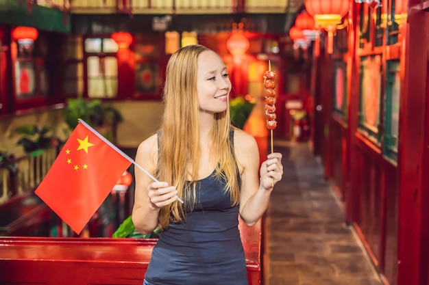 Urlaub in China genießen glückliche Touristin mit chinesischer Flagge und traditionellem Chinesisch
