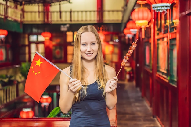 Urlaub in China genießen glückliche Touristin mit chinesischer Flagge und traditionellem Chinesisch