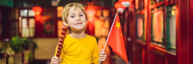 Urlaub in china genießen glücklicher touristenjunge mit chinesischer flagge und traditionellem chinesen