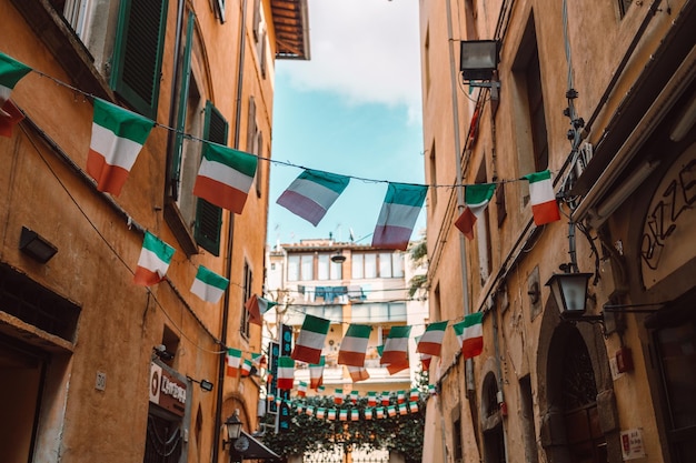 Urlaub in der italienischen Straßenstadt mit italienischen Flaggen und antiken GebäudenPisa Italien