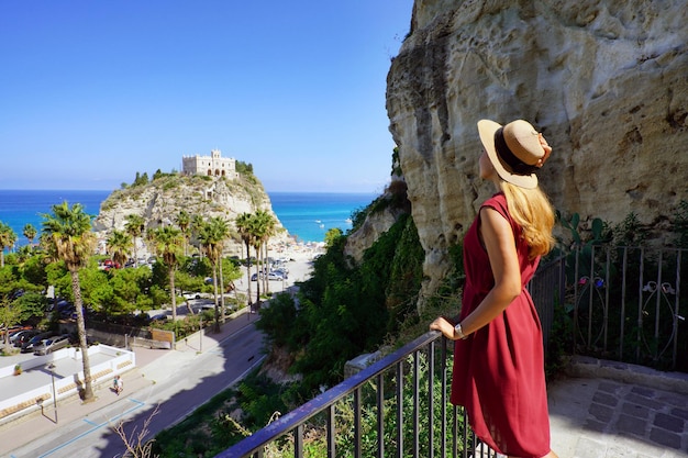 Urlaub in Tropea Rückansicht des schönen Modemädchens mit Blick auf das Kloster Santa Maria dell'Isola von Tropea Sommerurlaub in Italien