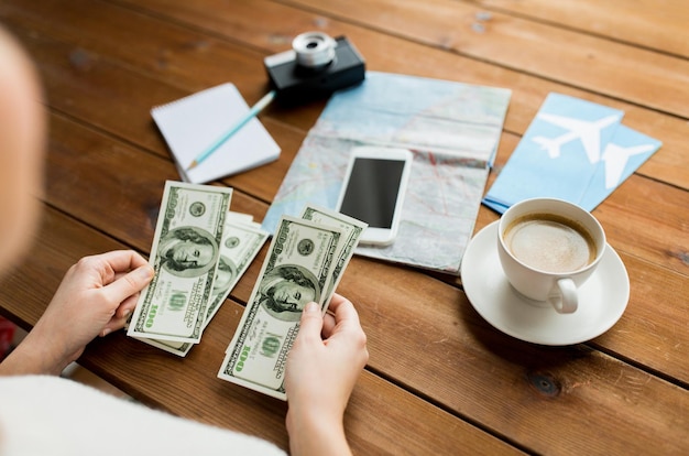 urlaub, tourismus, reisen, finanzen und personenkonzept - nahaufnahme der reisenden hände, die dollar bargeld zählen