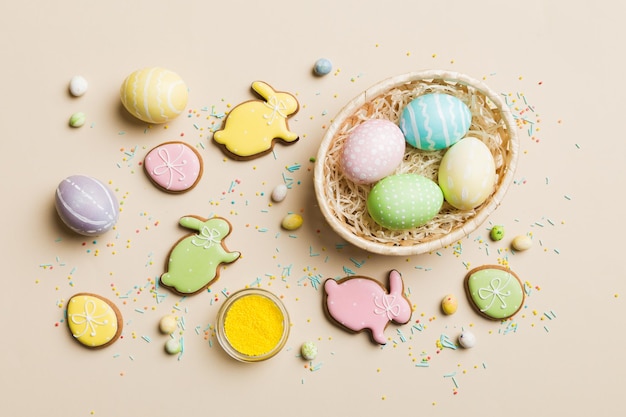 Urlaub Vorbereitung Multi Farben Ostereier mit Keksen auf farbigem Hintergrund Pastellfarbene Ostereier Urlaubskonzept mit Kopierbereich