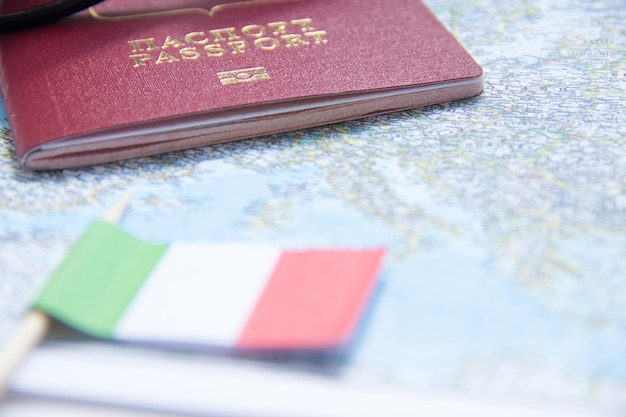 Urlaubskonzept Sonnenbrillen kleine italienische Flagge und Reisepass auf der Karte
