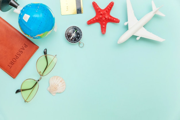 Urlaubsreise Reisekonzept. Flugzeug Reisepass Sonnenbrille Globus Gold Kreditkarte auf blauem Hintergrund