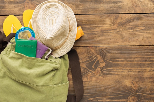 Urlaubsreise Sommer Traveller Rucksack mit Pässen und Urlaubsartikeln auf Holztisch