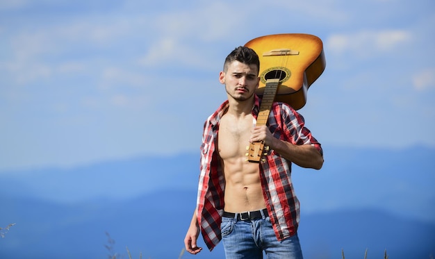 Urlaubsziele Kerl Wanderer genießen Natur pur Erkunden der Natur Schönheit der Natur Der beste Weg, um aus der Stadt zu entkommen Frische Bergluft Alleine spazieren Mann mit Gitarre zu Fuß auf dem Gipfel des Berges