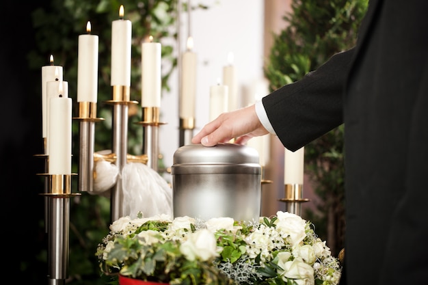 urna funerária com velas e flores