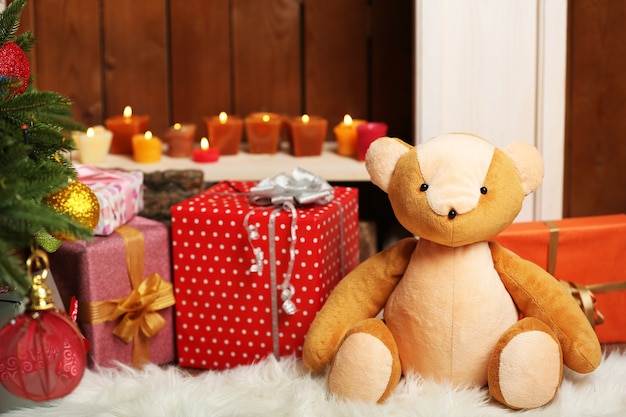 Urso de pelúcia com presentes de natal no quarto