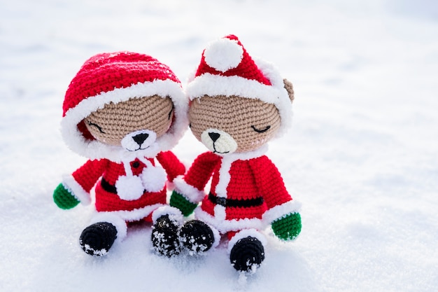 Urso de pelúcia de malha usando fantasia de Papai Noel na neve