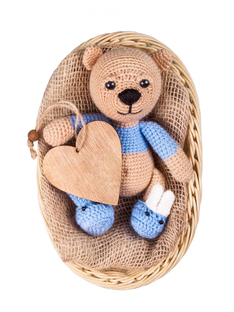 Foto urso de pelúcia na cesta e coração de madeira