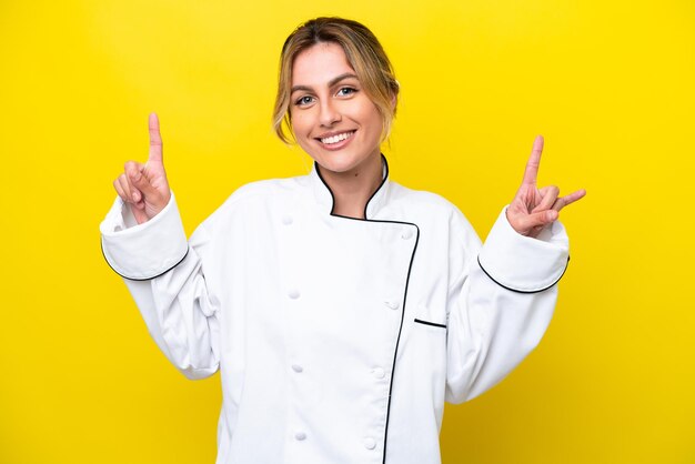 Uruguayische Kochfrau isoliert auf gelbem Hintergrund, die auf eine großartige Idee zeigt