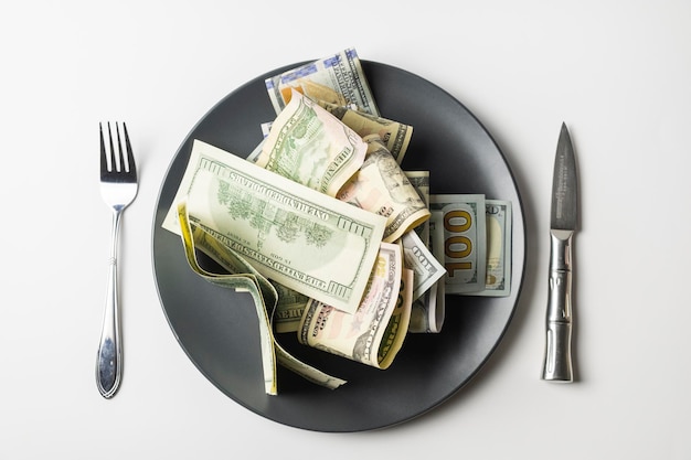 US-Dollar auf dem Teller mit Gabel und Messer
