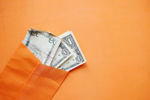 US-Dollar in einem orangefarbenen Umschlag